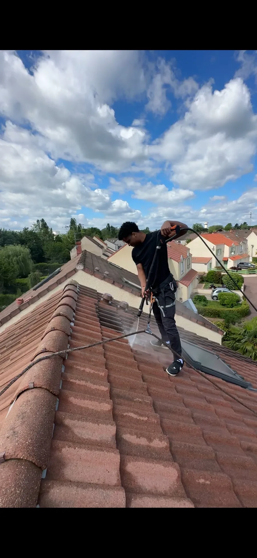 Thomas Tranchot sur un toit pendant un nettoyage de tuiles