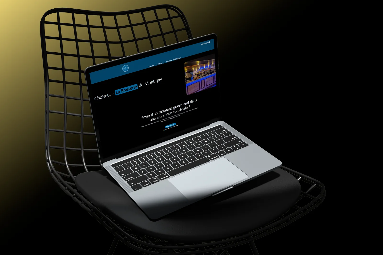 Le site du Choiseul affiché sur un ordinateur portable posé sur une chaise design