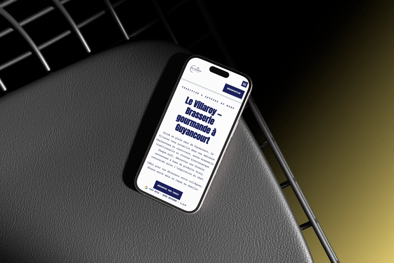 Le site du Villaroy affiché sur un téléphone posé sur une chaise design